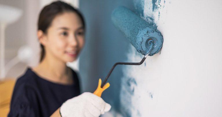 Young woman painting the walls