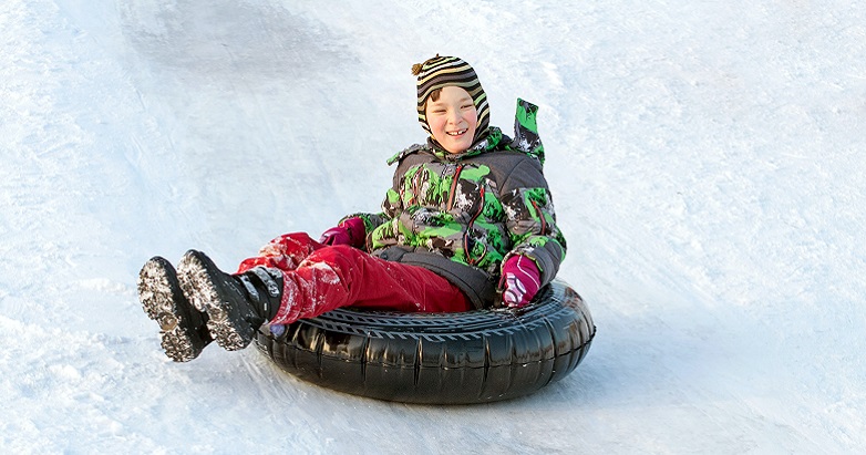 boy on an inner tube, sledding