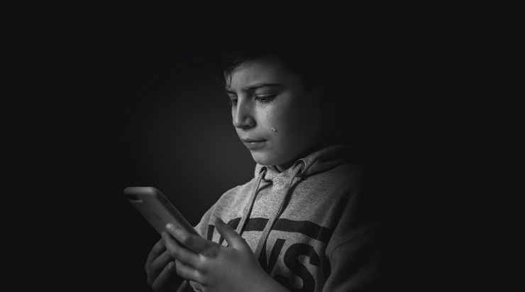 Sad young man looking at phone