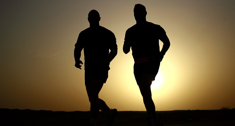 Silhouette of two men running