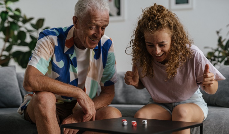 Elderly man and young woman rolling dice
