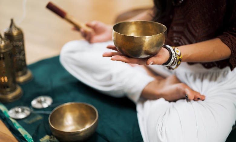 Person meditating with singing bowl