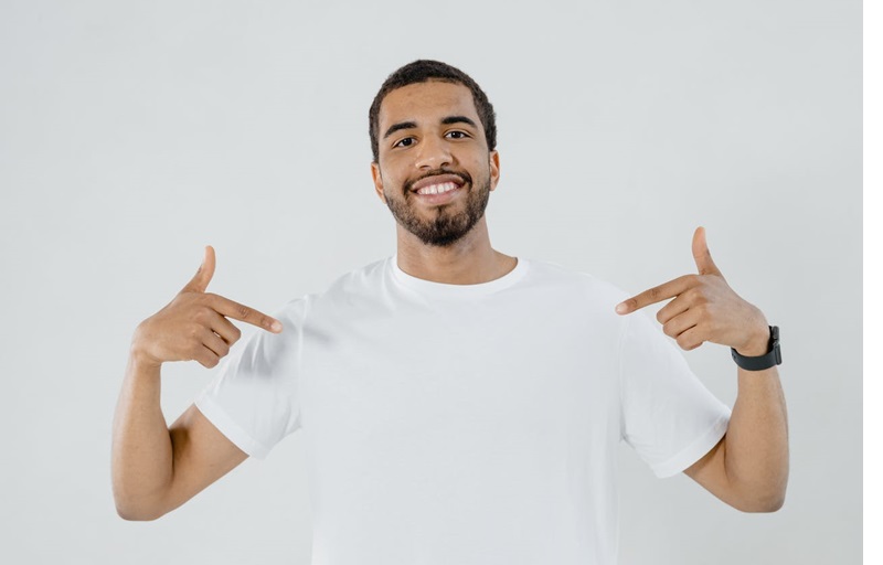 Man in white tee shirt pointing at himself