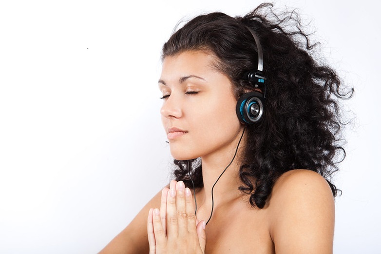 Woman with praying lands, listening to headphones