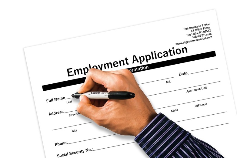 hand holding a pen, filling out employment application