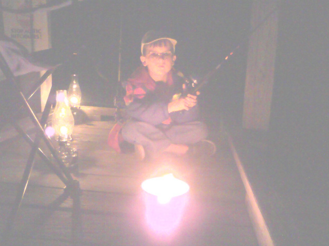 Little boy fishing by lantern light