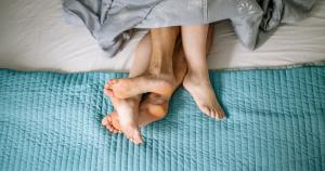 a couples feet in bed