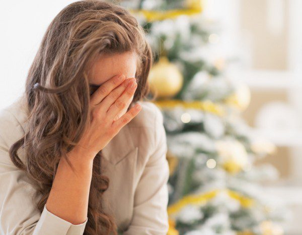 Stressed young woman in front of christmas tree