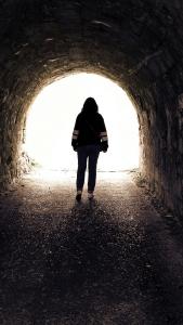 Woman walking out of tunnel