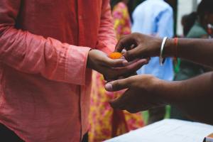 A hand putting something in another hand