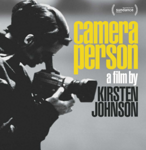 image of a woman with her eye to a camera. to the right of her head are the words "camera person: a film by kirsten johnson" in yellow, white, and black narrow block type. 