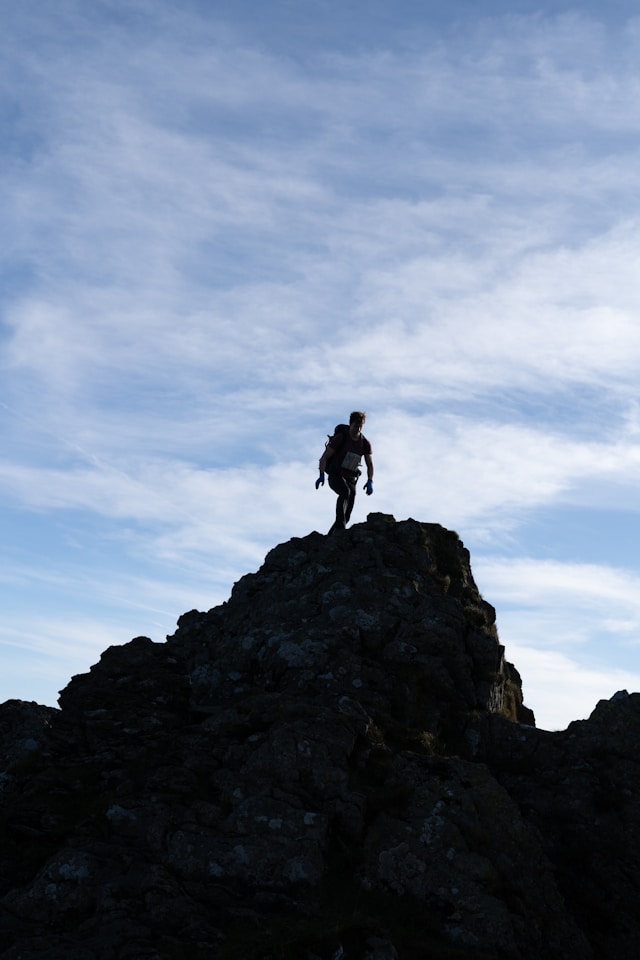 Climber at summit showing rising to faith challenge during wilderness season