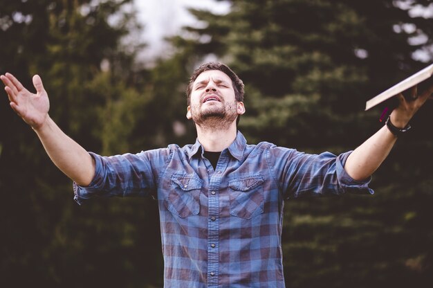 Person with arms raised toward sky in worship and surrender trusting God as ultimate provider and source