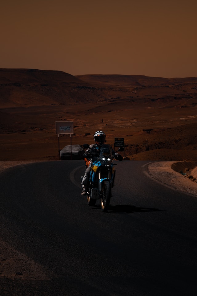Motorcycle on empty desert road illustrating testimony of supernatural provision and God turning water into fuel