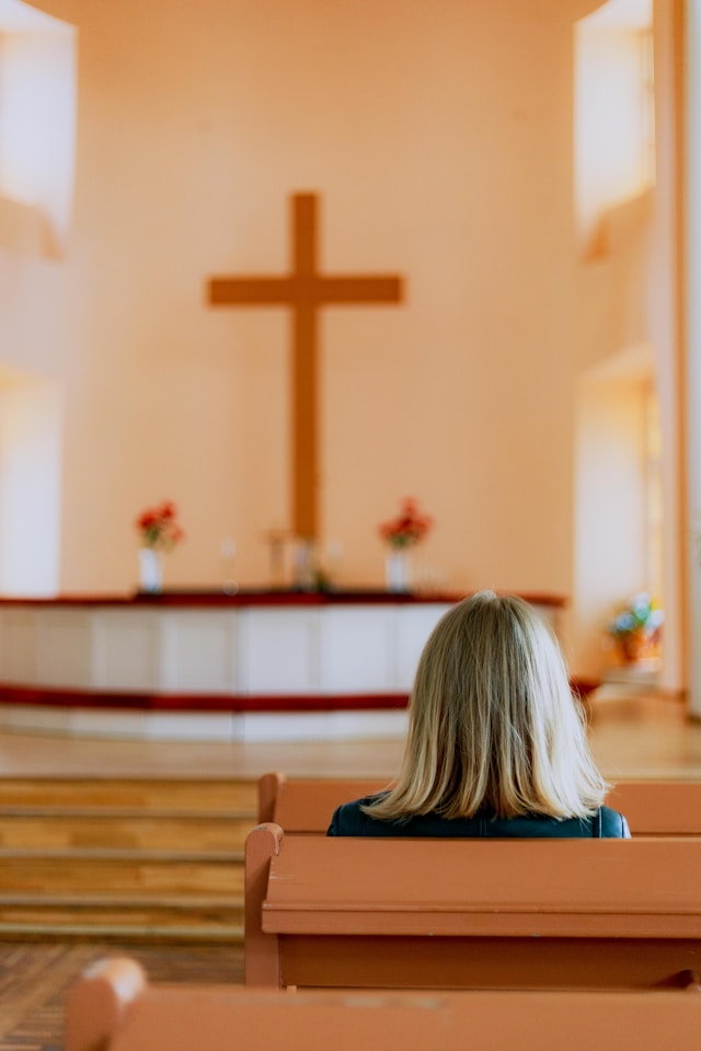 A woman sitting in a church pew