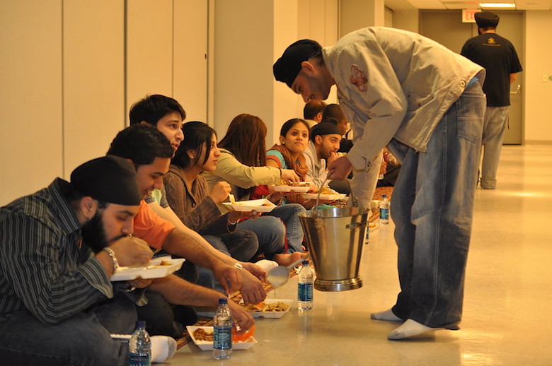 Langar meal served in a Sikh community, people eating on the ground