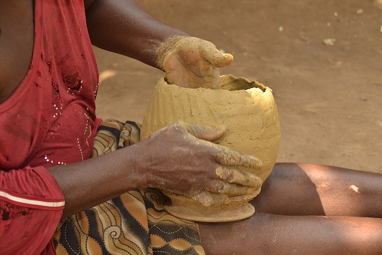Hands shaping a clay pot in Nigeria