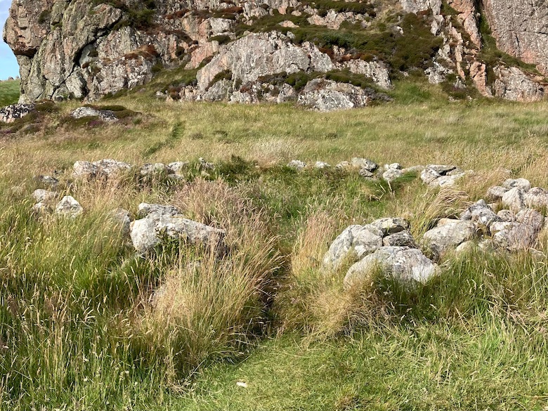 the hermit's cell, a ring of ruined stones at the base of a grassy hill