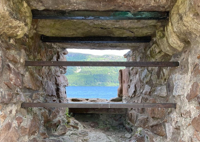 looking out to Loch Ness through a stone window with iron bars