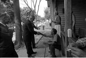 Source: Wikimedia Commons (photo by Cecil Stoughton): President Lyndon Johnson shakes the hand of one of the residents of Appalachia during his 1964 Poverty Tour. 