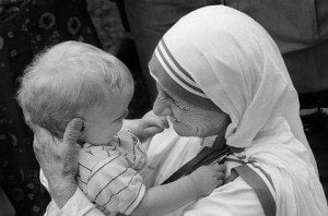 Mother Teresa, the 1979 Nobel Peace Prize laureate, came to Kentucky to oversee the opening of the first rural mission in the USA for the Missionaries of Charity. Located in the Appalachian community of Jenkins, KY, the St. George Catholic church held two masses on successive days, June 18 and 19, 1982 to honor her and officially open the mission. On June 21 and 22, Mother Teresa came to Louisville, KY to receive the Bellarmine Medal, the highest honor from Bellarmine College. She held a small press conference the spoke to the crowd of 4,000 who waited hours to hear her. Mother Teresa holds Louis Kluesener following a Mass at the St. George Catholic church in Jenkins, KY.