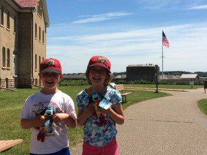 The kids holding their "History Hounds" at Fort Snelling