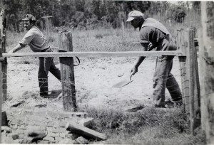 Two CPS workers covering an old privy hole at Camp 27 near Mulberry, FL