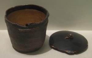 jomon pot- a small clay pot with a lid and a gilt interior