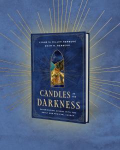 The cover of "Candles in the Darkness: Experiencing Advent with the Early and Medieval Church." A royal blue book on a lighter blue background, with gold rays of light. The center of the book contains a stained glass window motif.