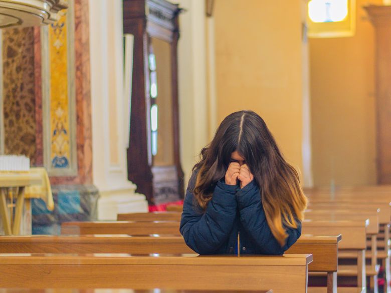 a woman praying for vocation in Church