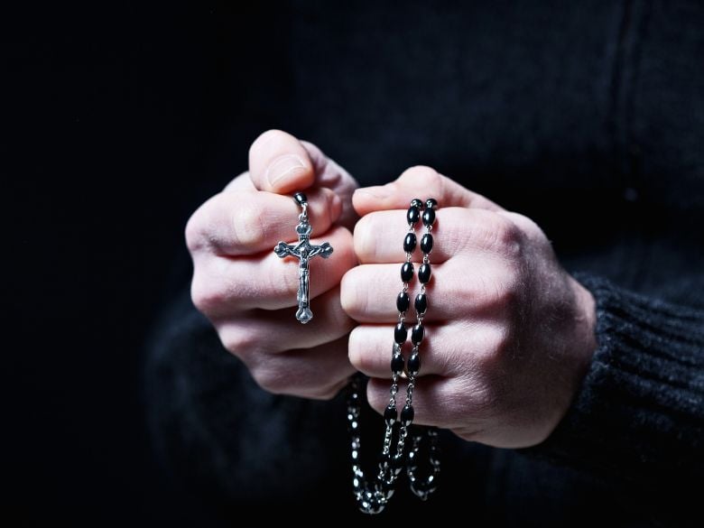 a Catholic praying the holy rosary