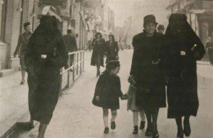 Muslim woman covers the yellow star of her Jewish neighbor with her veil on the streets of Sarajevo in 1941.