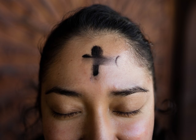 A woman with ashes on her forehead in the shape of a cross on Ash Wednesday