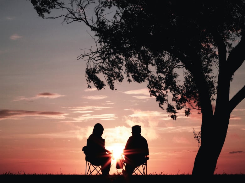 Interfaith friends watching the sun set. 