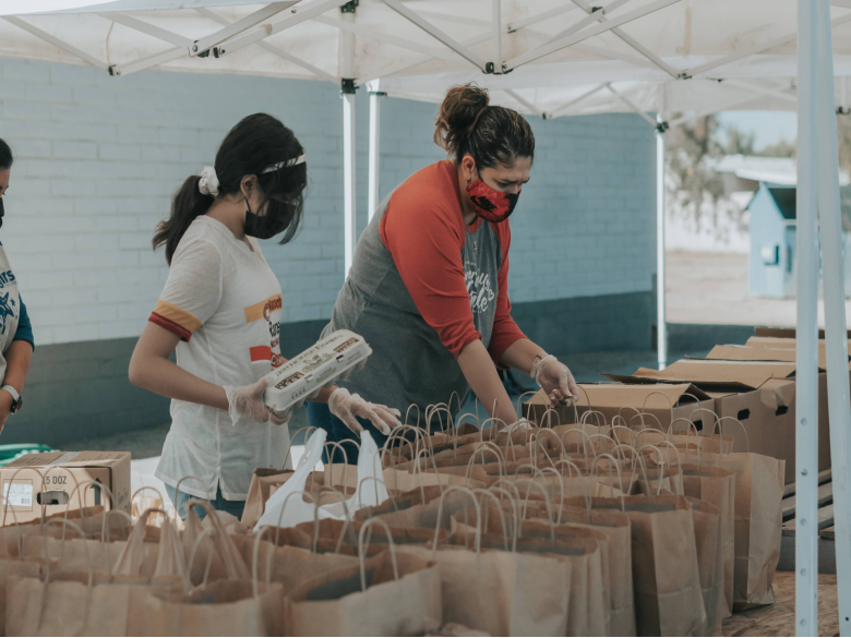 Volunteers packing food in bags at a food pantry.