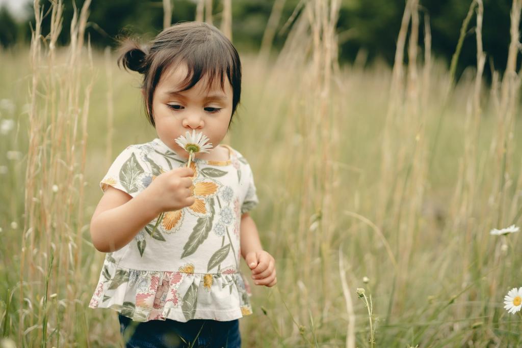 Little girl with flower to her face smelling it
