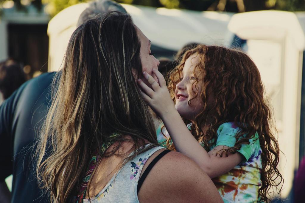 mom holding daughter, both smiling, and daughter is grabbing mom's face