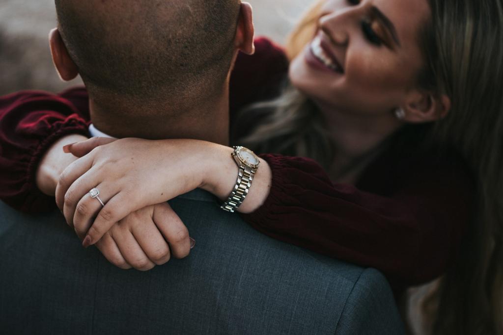 happy couple, woman with arms around husband's neck smiling
