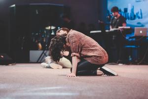 Kneeling in prayer at a revival