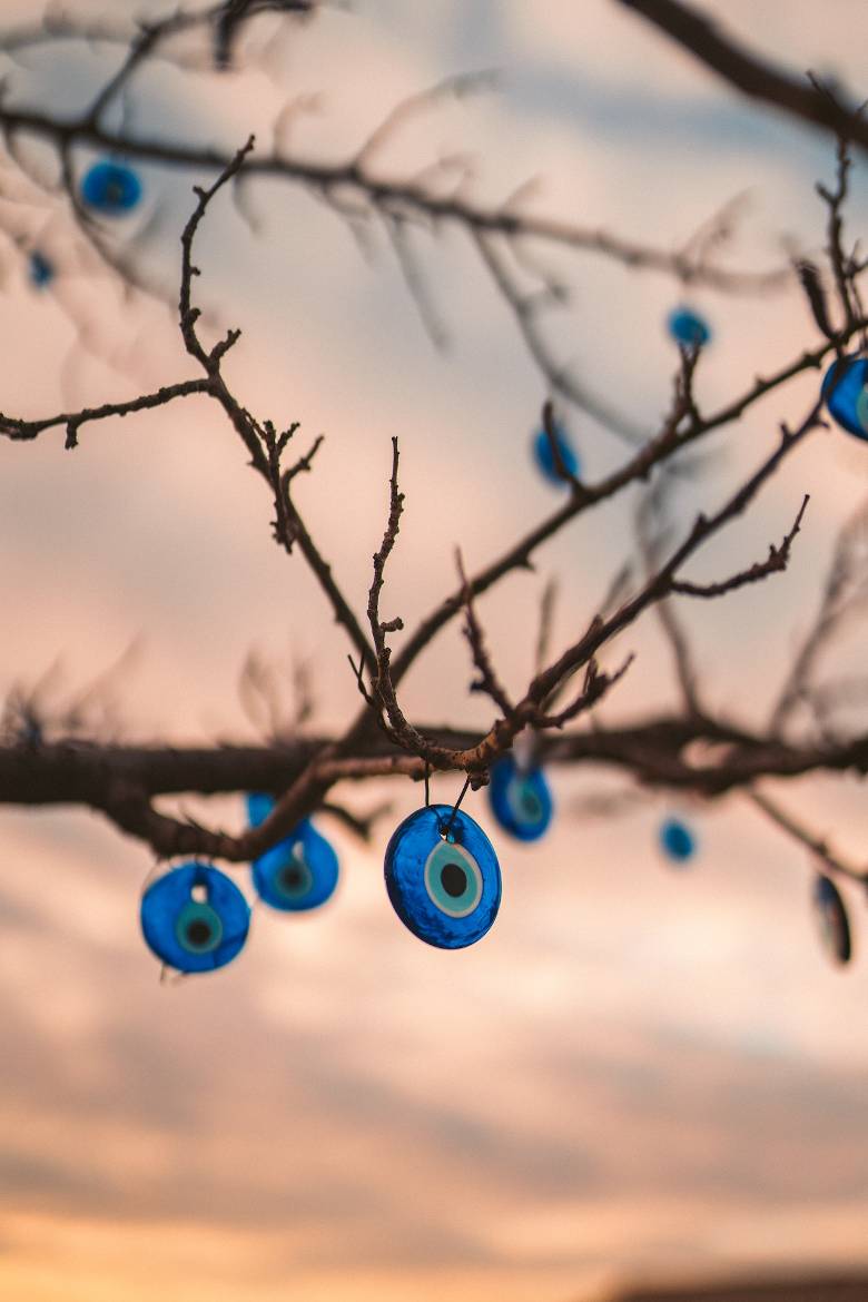 Glass "evil eyes" adorn a tree branch.