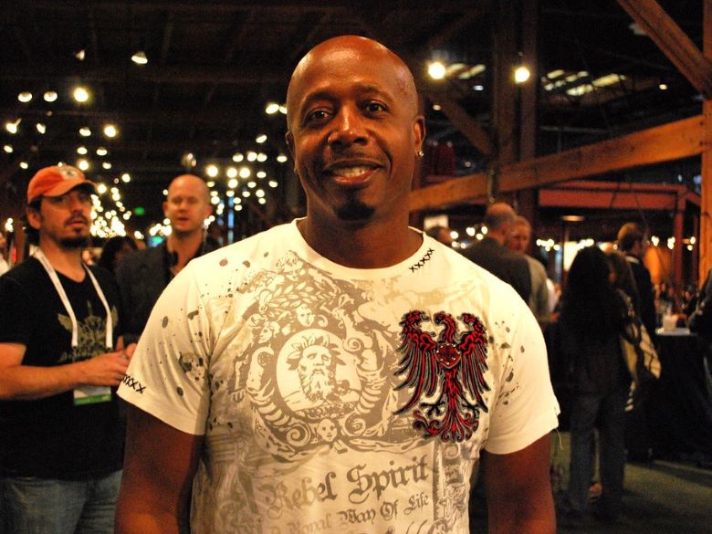 MC Hammer at an event with some people and lights in the background