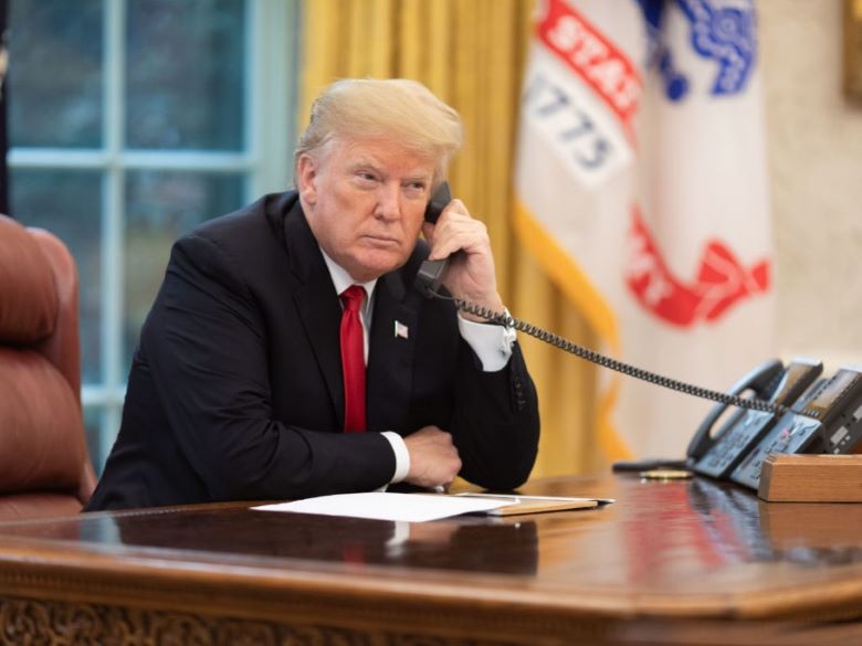President Trump on the phone in the Oval Office looking serious