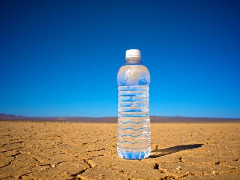 Single clear glass of cold water offers refreshment in the dry, hot, flat, dusty desert.