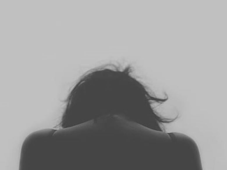 Rear view of person from shoulders up experiencing grief