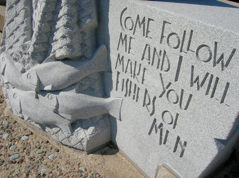 Closeup of base of monument in Chicago Cemetery. Inscription: "Come follow me and I will make you fishers of men." With some fish alongside.