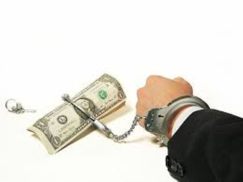 A man's wrist handcuffed to a dollar bill