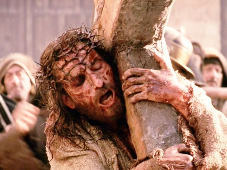 Closeup of bloody Jesus carrying the cross