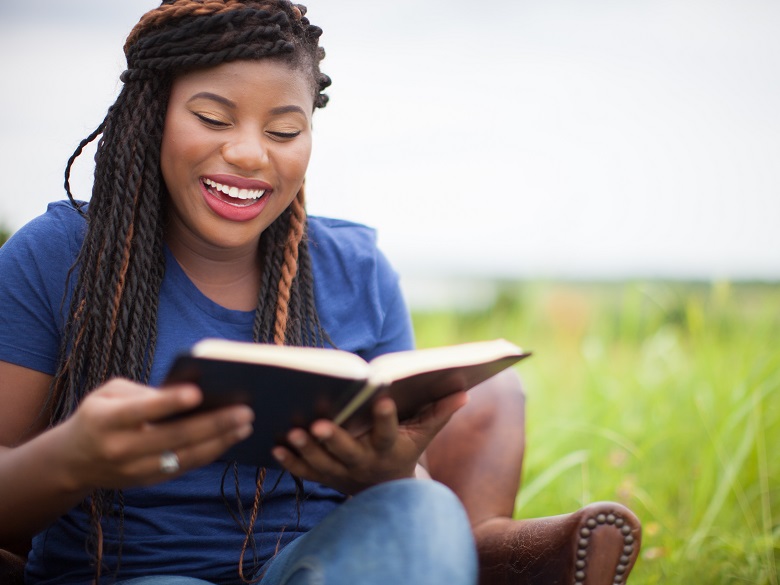 Woman reading Bible and smiling