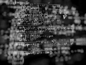 Mathematical formulas in white overlaid over a black background. 