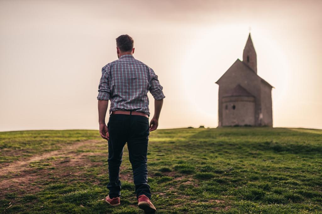 Man walking towards small church in the distance